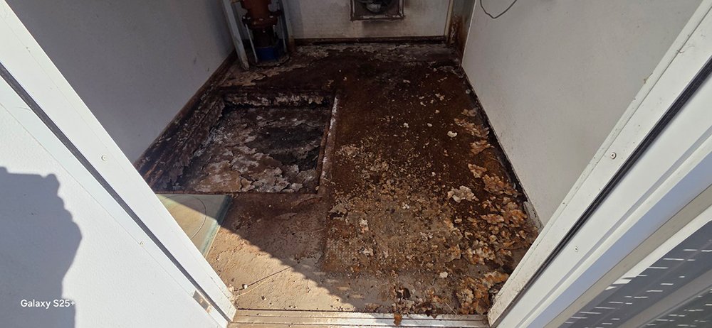 A before-and-after view of a small utility room floor showing heavy rust and corrosion being removed through professional mobile blasting.